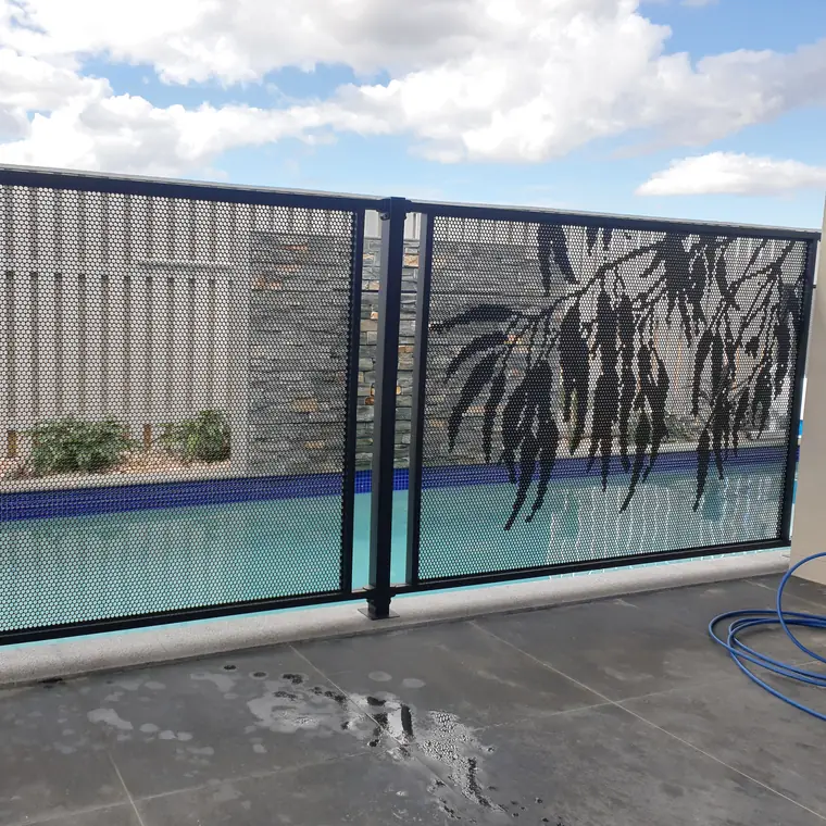 A black PoolPerf panel with the Gum design, a spray of gum leaves, beside a lap pool